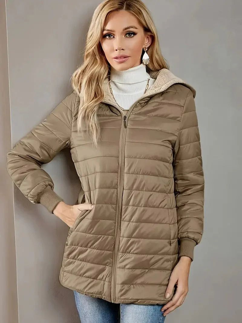 De vrouw draagt een knus jack met capuchon, perfect voor koele herfst- en winterdagen.