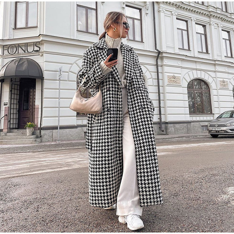 Moderne trenchcoat met houndstooth-patroon, elegant en warm, ideaal voor stijlvolle herfst- en winterlooks.