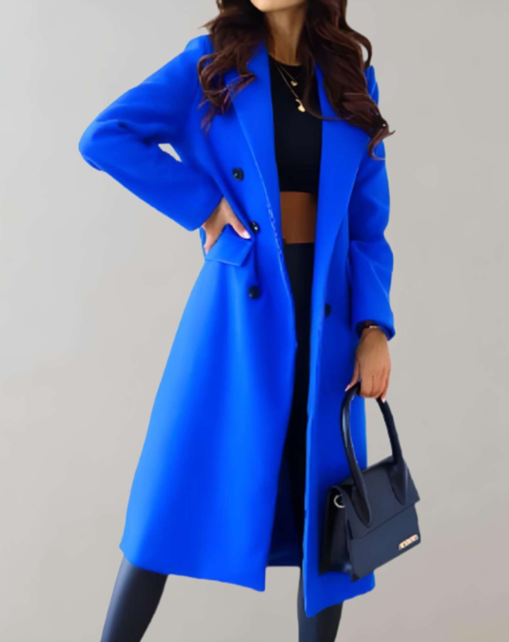 Vrouw draagt een casual trenchcoat jas voor herfst of winter dagen, gecombineerd met elegante handtas voor een veelzijdige stijl