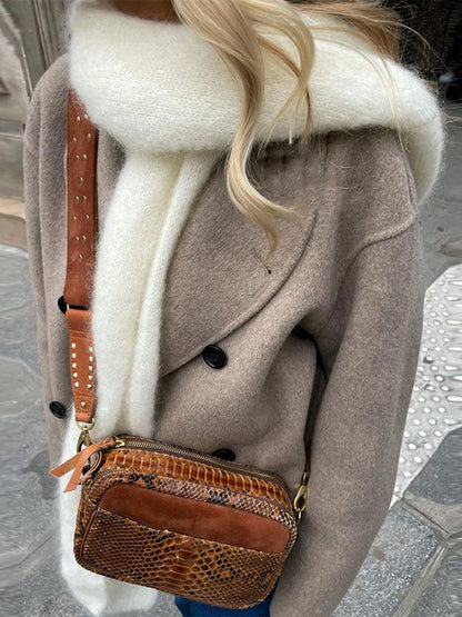 Elegante wollen jas van hoogwaardige wollen stof, met double-breasted sluiting en brede reverskraag, ideaal voor herfst- of winterdagen.